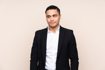 Asian business man isolated on beige background standing and looking to the side
