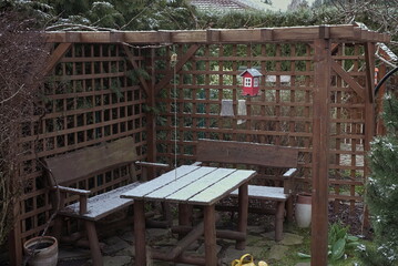 Garden gazebo with a table covered with snow in the winter 