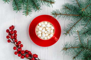 Red cup of coffee with marshmallow and Christmas tree on white wooden table. New Year decorations,...