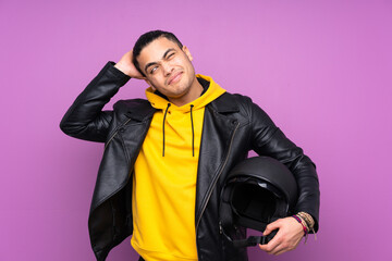 Man with a motorcycle helmet isolated on purple background having doubts and with confuse face...