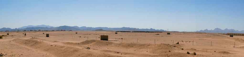 Panoramic view of the endless desert and high mountains against the backdrop of the blue sky....
