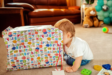 Happy baby boy sitting on carpet playing with toys – creativity, curiosity and early development concept for infants
