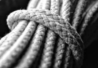 Shallow depth of field, high contrast, detailed/textured black and while still life photo of rope. 