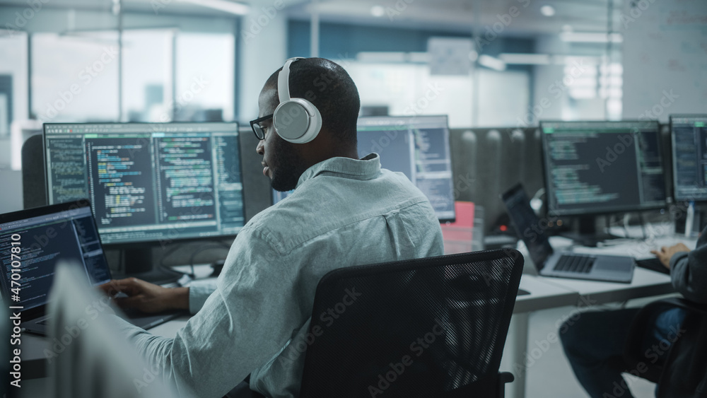 Poster Office: Professional Black IT Programmer Uses Headphones while Working on Desktop Computer. Male Website Developer, Software Engineer Developing App, Video Game. Listening to Podcast, Music.