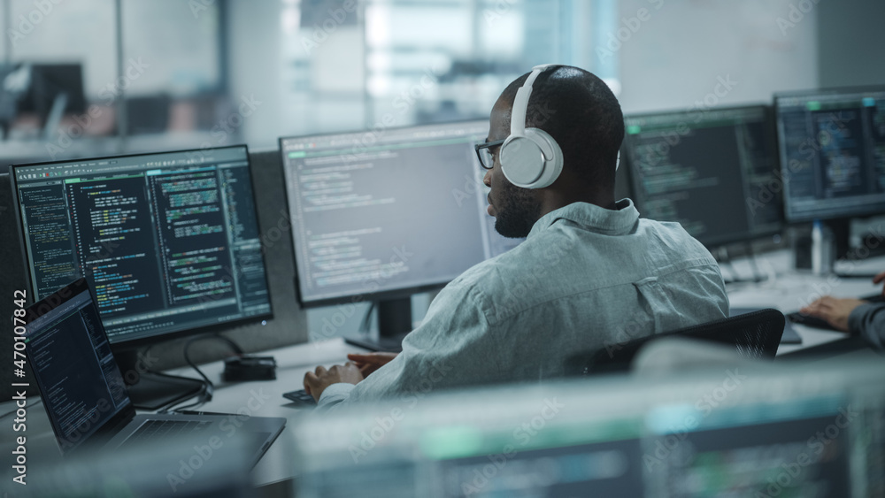 Poster Office: Professional Black IT Programmer Uses Headphones while Working on Desktop Computer. Male Website Developer, Software Engineer Developing App, Video Game. Listening to Podcast, Music.