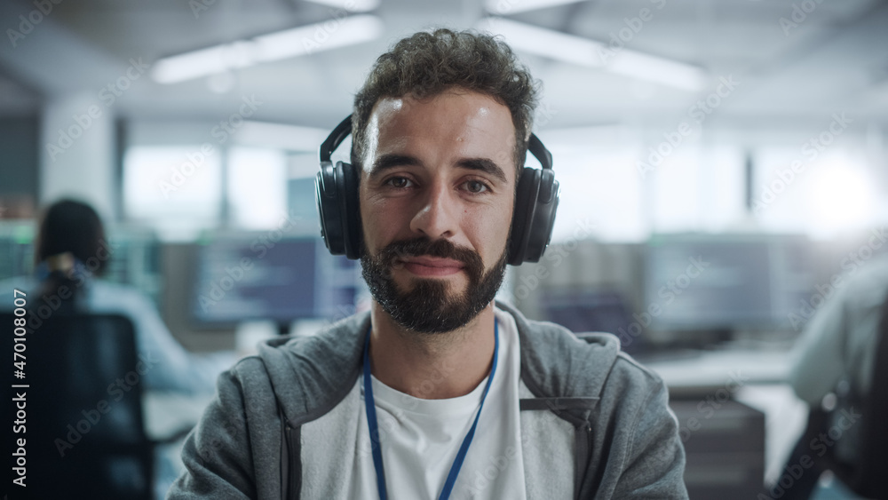 Leinwandbilder office: portrait of happy it programmer wearing headphones working on desktop computer. male softwar