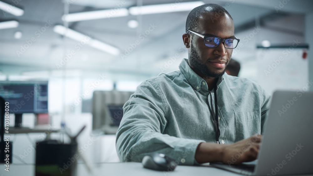 Aufkleber modern office: portrait of motivated black it programmer working on laptop computer. male specialist
