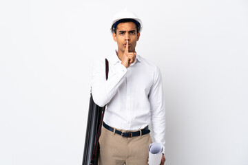 African American architect man with helmet and holding blueprints over isolated white background _ showing a sign of silence gesture putting finger in mouth