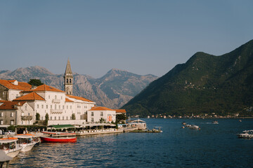 Fototapeta na wymiar Pier with boats in the background of Perast buildings. Montenegro