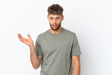 Fototapeta premium Young caucasian handsome man isolated on white background making doubts gesture
