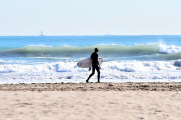 surfer walking on the beach
