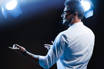 Motivational speaker with headset performing on stage