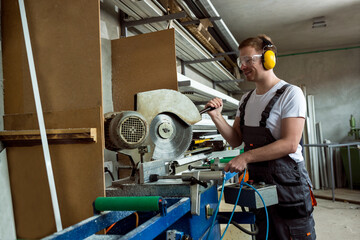 Worker in the workshop cuts the pvc profile