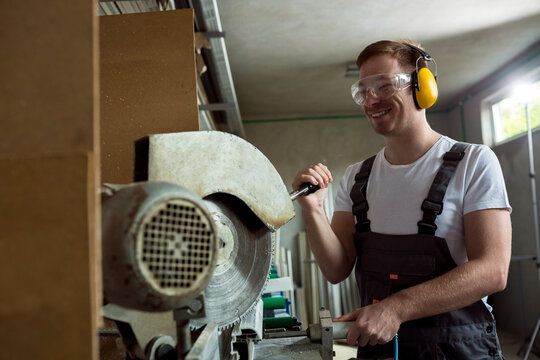 Worker in the workshop cuts the pvc profile