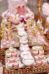 Fototapeta na wymiar pink cupcakes, cakes and macarons at a candy bar, decorated with caramel bows and swans