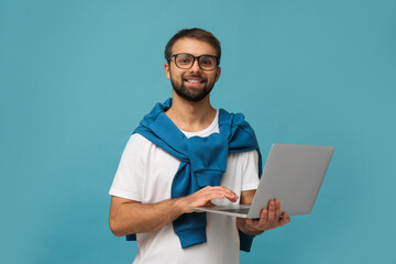 Student using laptop on light blue background