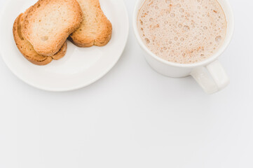 delicious hot vegan Cappuccino with foam in a white cup with crispy rusks on a white background