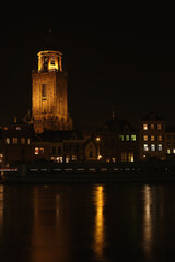 Fototapeta na wymiar The Great Church and buildings in the City of Deventer, the Netherlands, at night with reflection in the water