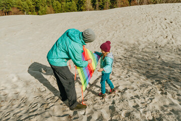 Dad and daughter having fun time on the sand beach