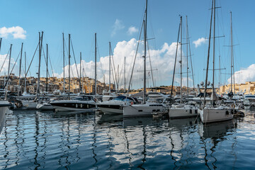 Fototapeta na wymiar Luxury boats and yachts in the harbor. Sunny summer day. Holiday high-class lifestyle travel concept. Boat trip in the Mediterranean.View of expensive sailing yachts at the pier.Marine dock.