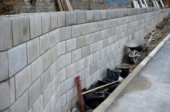ugly holding a road notch of a bridge forecourt tunnel. retaining wall with concrete grouting is covered with fake, optically prettier wall. fencing with hollow bricks filled with wires, railing,steel