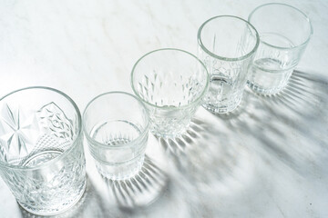 Empty drink glasses on white kitchen table.