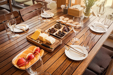 A table served with snacks - fruits, various cheeses and olives - at the winery for winetasting tour