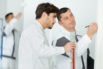 men checking wall with professional aluminum level