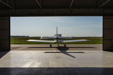 A small private jet on the landing site before takeoff. Back view.