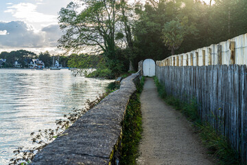 romantischer Uferweg mit altem Tor; Frankreich, Bretagne, Finistere, in der Bucht von la...