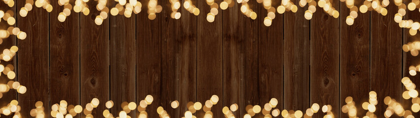 Frame of lights bokeh golden flares, isolated on rustic brown wooden texture - Holiday New Year's...