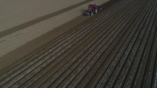 Farmers use planters to plant plastic coated peanuts on farms, North China