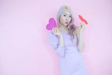 Obraz na płótnie Canvas Portrait beautiful asia woman on pink background, happy valentine day in love concept, model holding red heart sign in hand