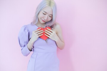 Portrait beautiful asia woman on pink background, happy valentine day in love concept, model holding red heart sign in hand