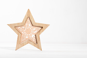 Fototapeta na wymiar wooden christmas star decoration on a white wooden backgroud with copy space, eco wooden Christmas decor for home, waste-free festive decoration concept