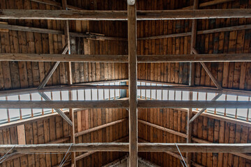 Bottom view of an old beams and wooden roof. Inside an old barn.