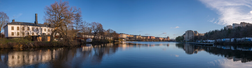 Obraz premium Old building at the channel Klarabergskanalen at the castle Karlbergs Slott reflecting in water a sunny autumn day in Stockholm
