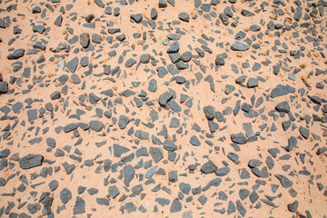 Yellow sand on black stone floor top view background
