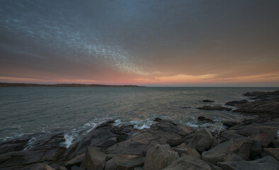 Long exposure shot of red granit rocks on the sea at amazing sunset - Namibia