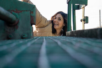 cheerful and friendly young brunette woman making expressive faces on the gangway of a freight...