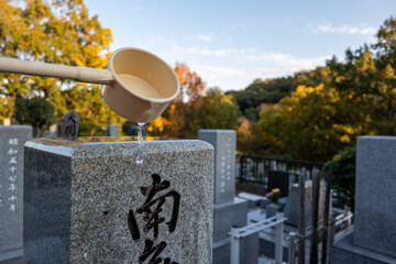 墓石に水をかける　墓参り・供養　イメージ　Japanese style grave with offering...