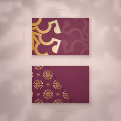 Burgundy business card with abstract gold ornament for your personality.
