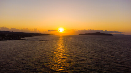 Beautiful blazing sunset landscape at black sea and orange sky above it with awesome sun golden reflection on calm waves as a background. Amazing summer sunset view on the beach