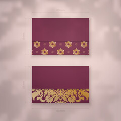 Burgundy business card with Greek gold pattern for your brand.