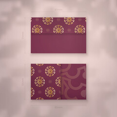 Burgundy business card with Greek gold pattern for your business.