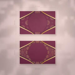 Burgundy business card with Indian gold ornaments for your business.