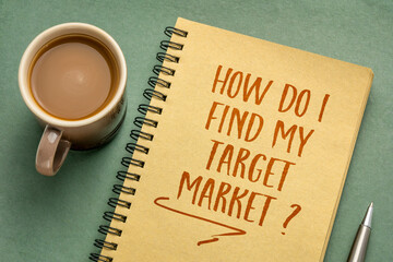 How do I find my target market? Handwriting in a notebook with a cup of coffee, business marketing concept.