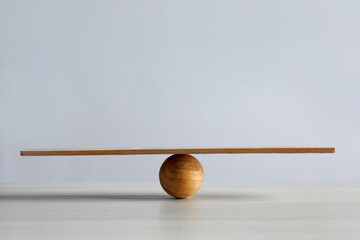 Wooden ball with small plank on table, space for text. Harmony and balance concept