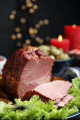 Delicious ham served with lettuce on plate against blurred festive lights. Christmas dinner