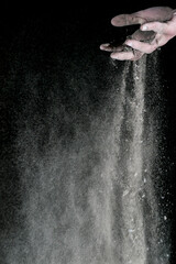 Studio shot of a man's hand with dust against black background